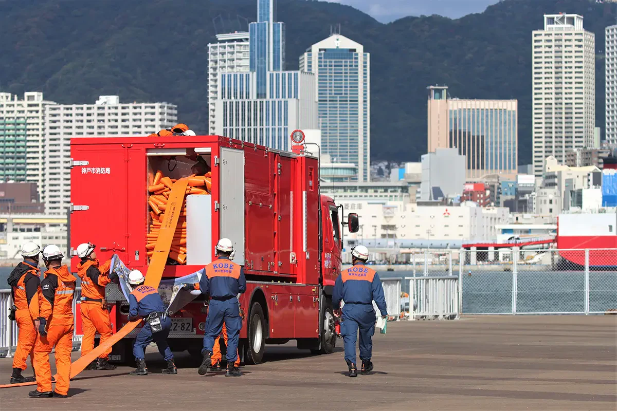 車両と隊員が息を合わせ、専用の大径ホースを延長する